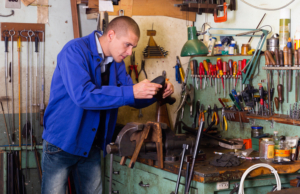 Gunsmith repairs butt of a shotgun in a weapons workshop