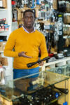African-american gunsmith demonstrating rifle scope for sale