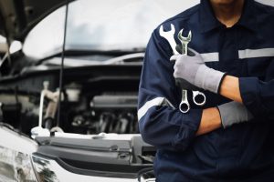 Hand of car mechanic with wrench. Auto repair garage. mechanic works on the engine of the car in the garage. Repair service. Concept of car inspection service and car repair service.