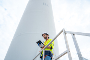 Engineer with technician are inspection work in wind turbine farms.