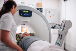 A radiology technician assists a patient during a CT scan, ensuring the patient is positioned correctly and comfortably as the machine captures detailed diagnostic images for medical analysis.
