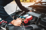 Close up hand of auto mechanic are to use measuring manifold gauge for filling car air conditioners. Concepts of fix and checking for repair service and car insurance.
