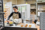 Pastry chef preparing filling for pastries in bakery kitchen