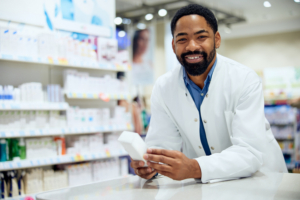 Friendly pharmacist holding a product in a well-stocked pharmacy, providing expert advice.