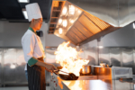 Asian chef man in dress white uniform cooking and handling pan with flaming work in kitchen restaurant. Cooking and food concept
